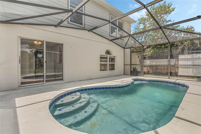 view of pool with a patio and glass enclosure