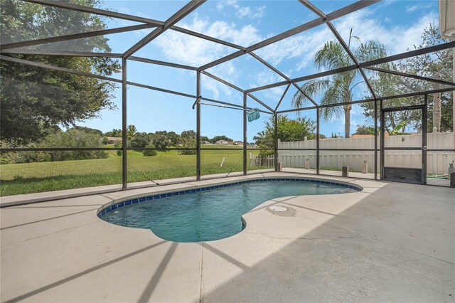 view of swimming pool with glass enclosure, a patio area, and a lawn