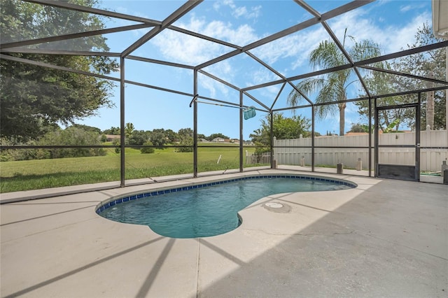 view of pool with a yard, a patio, and glass enclosure