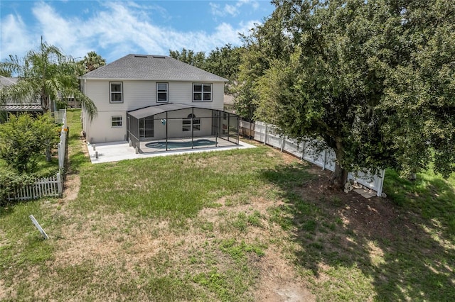 rear view of house featuring a patio, a lanai, a yard, and a fenced in pool