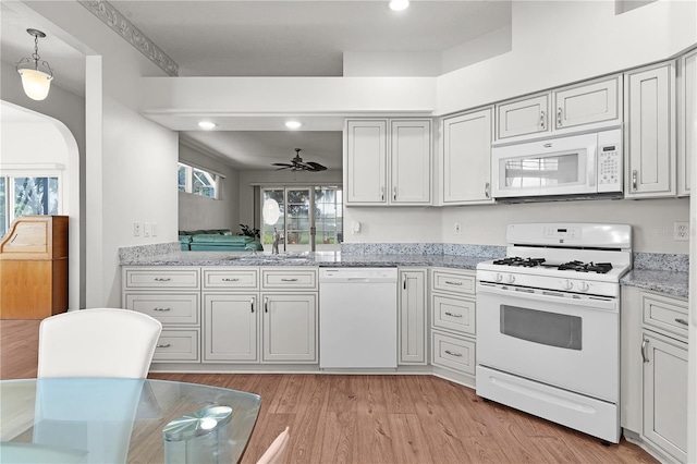 kitchen with ceiling fan, sink, hanging light fixtures, white appliances, and light wood-type flooring