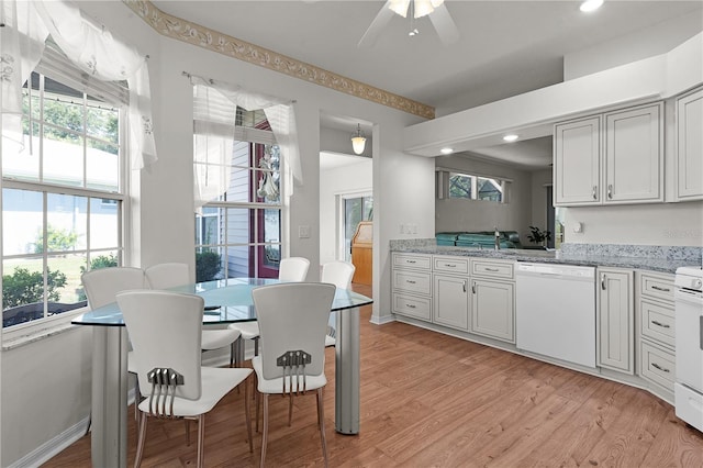 kitchen featuring light stone countertops, sink, ceiling fan, light hardwood / wood-style floors, and white appliances