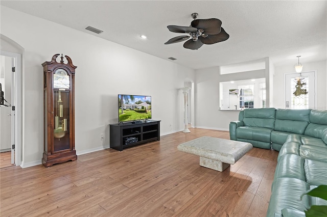 living room featuring ceiling fan and light hardwood / wood-style flooring