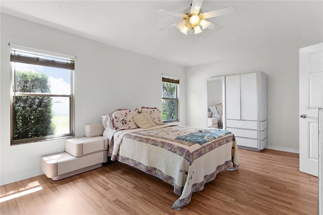 bedroom with light hardwood / wood-style floors and ceiling fan