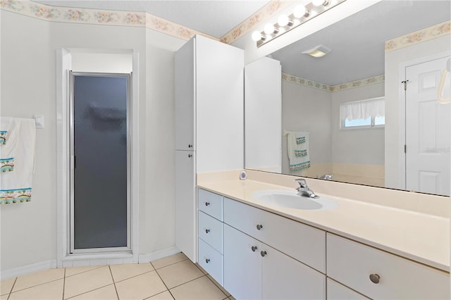 bathroom with tile patterned flooring, vanity, and a shower with door