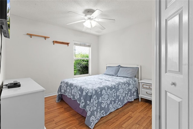 bedroom featuring a textured ceiling, hardwood / wood-style flooring, and ceiling fan