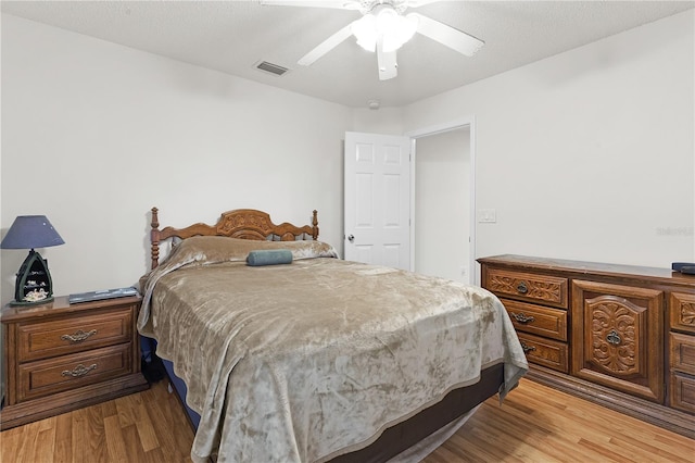 bedroom featuring ceiling fan, a textured ceiling, and light hardwood / wood-style flooring