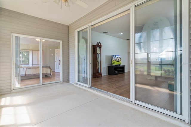 unfurnished sunroom with ceiling fan