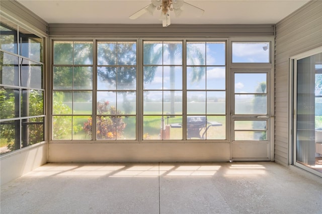 unfurnished sunroom with ceiling fan