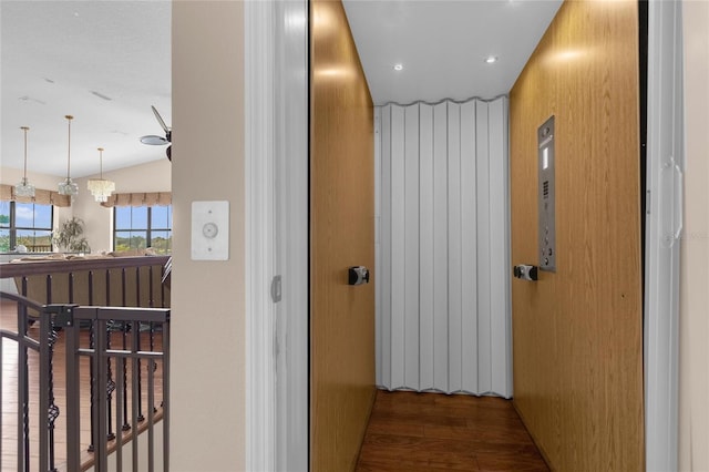 corridor featuring lofted ceiling and wood finished floors