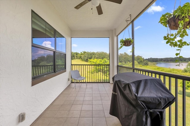 sunroom / solarium featuring a water view and ceiling fan