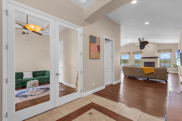 corridor featuring lofted ceiling, recessed lighting, baseboards, french doors, and tile patterned floors