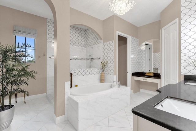 full bathroom with baseboards, a garden tub, marble finish floor, walk in shower, and vanity