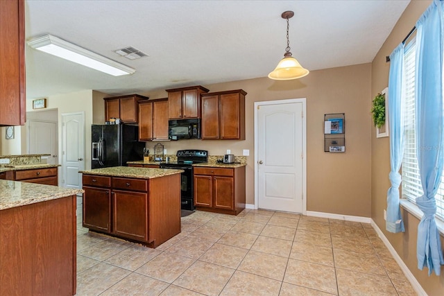 kitchen with light stone counters, light tile patterned flooring, hanging light fixtures, and black appliances