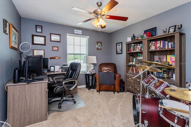 carpeted home office featuring ceiling fan