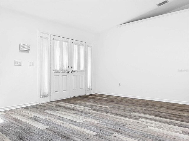 empty room with lofted ceiling and hardwood / wood-style floors