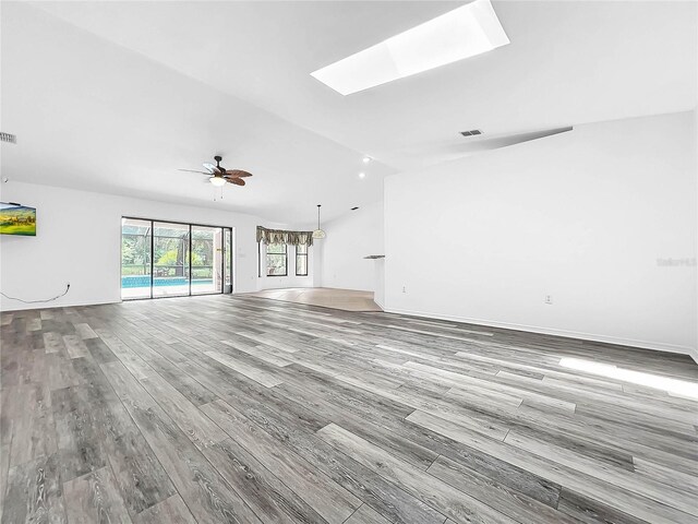 unfurnished living room featuring a skylight, hardwood / wood-style flooring, and ceiling fan