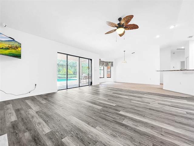 unfurnished living room with hardwood / wood-style flooring and ceiling fan