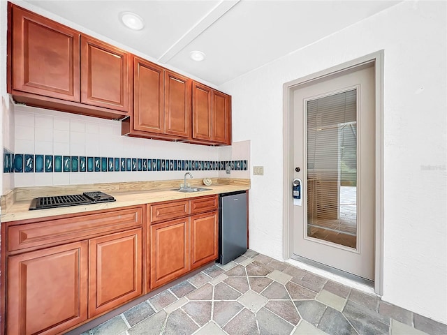 kitchen featuring sink, stainless steel dishwasher, light tile patterned floors, and tasteful backsplash