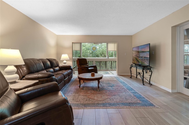 living room featuring light hardwood / wood-style floors and a textured ceiling