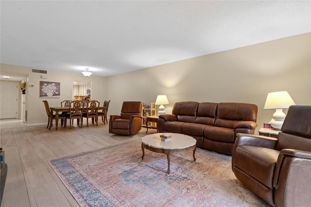 living room with light hardwood / wood-style floors and a textured ceiling