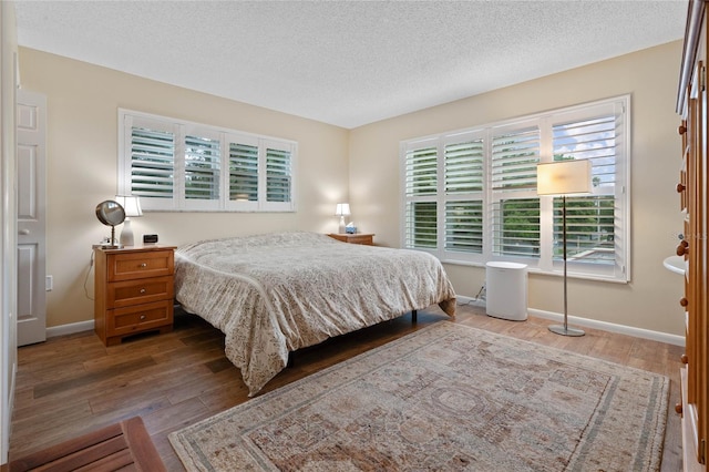 bedroom with wood-type flooring and a textured ceiling