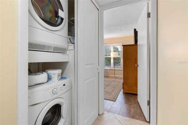 washroom featuring stacked washer / dryer and a textured ceiling