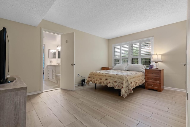 bedroom with a textured ceiling and ensuite bath