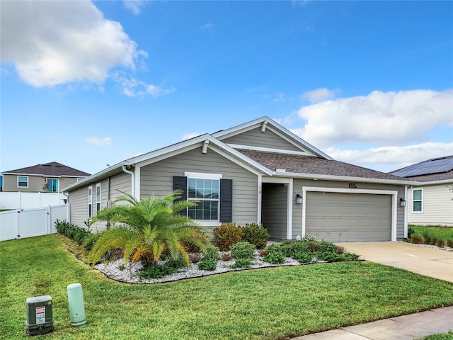 ranch-style home featuring a garage, solar panels, and a front yard