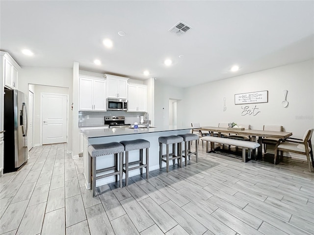 kitchen featuring sink, appliances with stainless steel finishes, light hardwood / wood-style floors, and white cabinetry