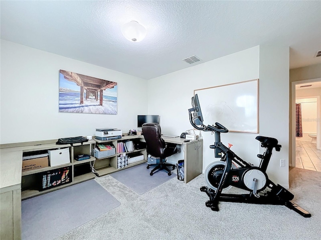 carpeted office featuring a textured ceiling