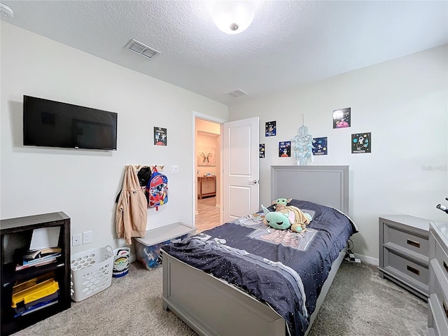 bedroom with light carpet and a textured ceiling