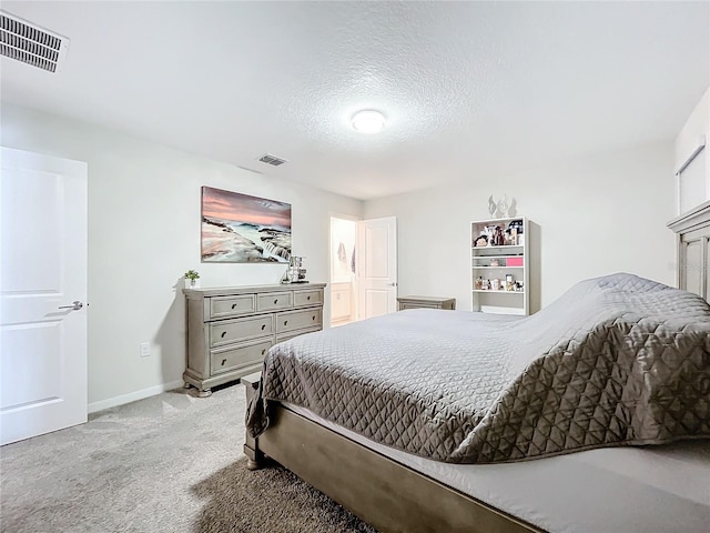 bedroom featuring a textured ceiling and light colored carpet