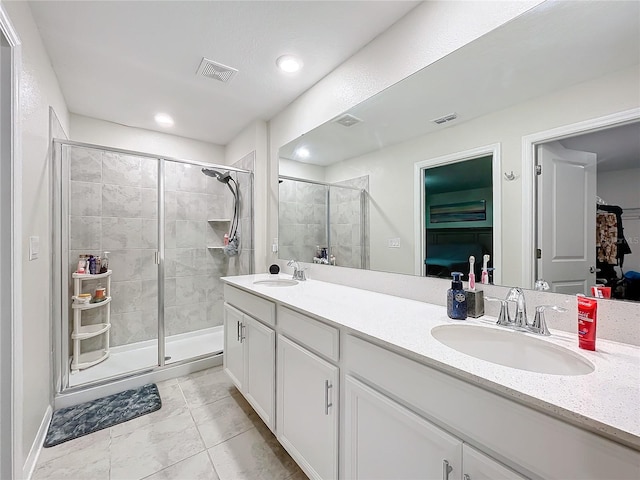 bathroom featuring an enclosed shower, tile patterned floors, and double sink vanity