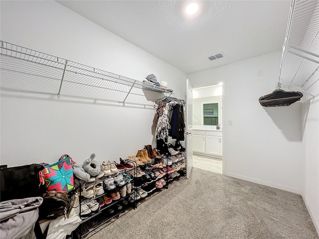 spacious closet featuring light carpet