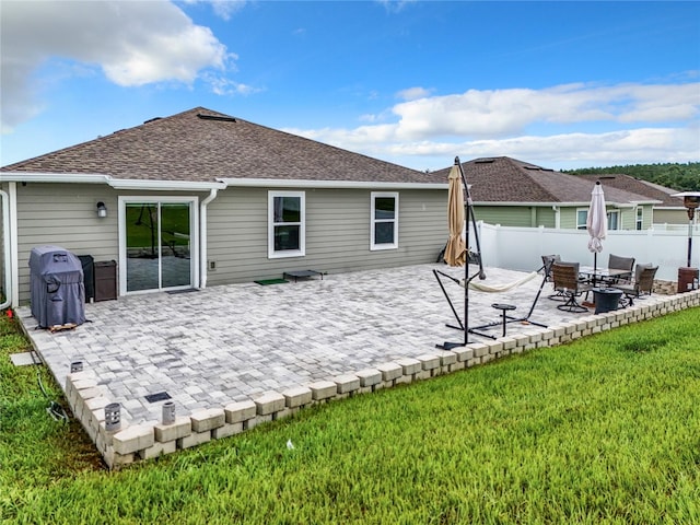 back of house featuring a lawn and a patio area