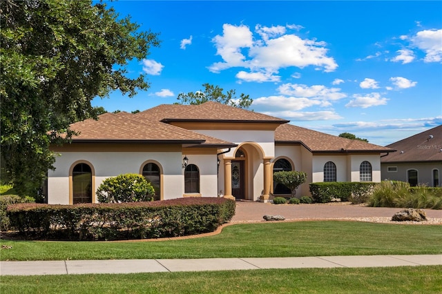 mediterranean / spanish home featuring a front lawn