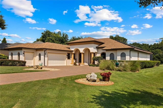 mediterranean / spanish-style house with a front lawn and a garage