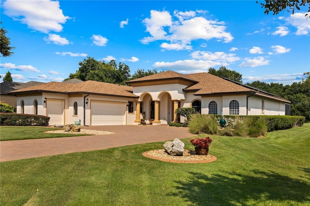 mediterranean / spanish house featuring a garage and a front yard