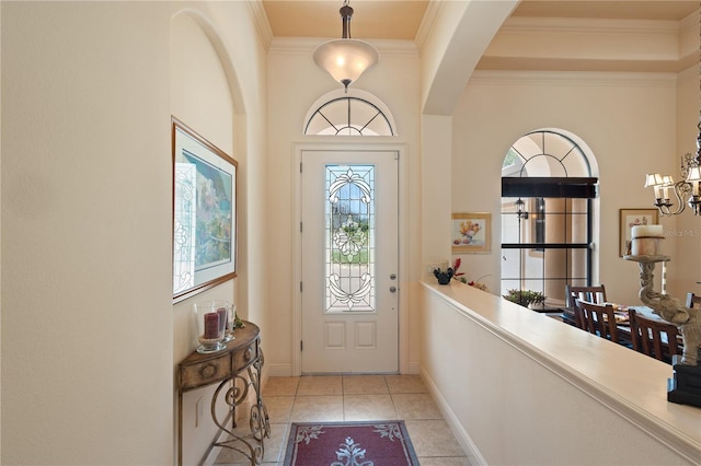 foyer entrance with crown molding and light tile patterned flooring