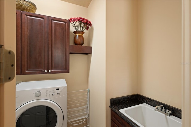 washroom with cabinets, washer / dryer, and sink