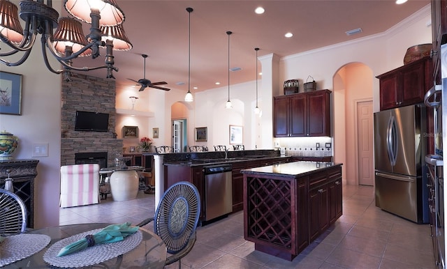 kitchen with kitchen peninsula, tile patterned floors, stainless steel appliances, and a kitchen island