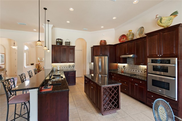 kitchen featuring kitchen peninsula, backsplash, stainless steel appliances, pendant lighting, and light tile patterned floors