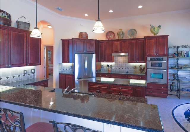 kitchen featuring tasteful backsplash, stainless steel appliances, sink, decorative light fixtures, and light tile patterned flooring