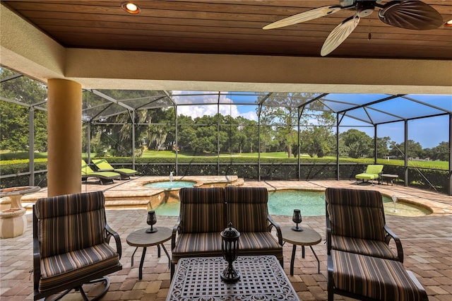 view of patio with a swimming pool with hot tub, ceiling fan, and a lanai