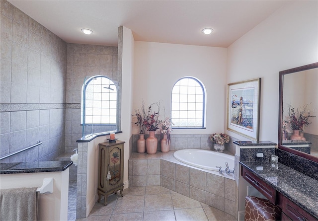 bathroom with vanity, a relaxing tiled tub, and tile patterned floors