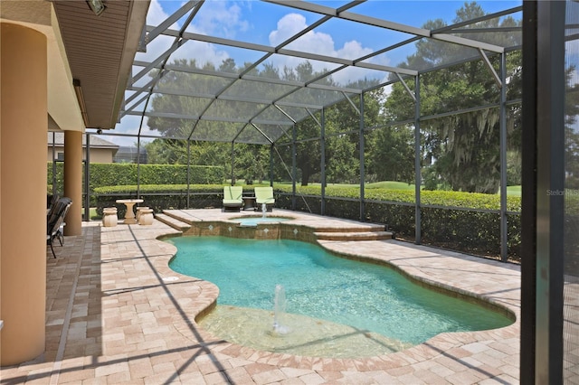 view of pool with glass enclosure, an in ground hot tub, and a patio