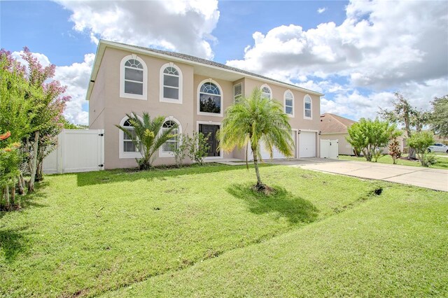 mediterranean / spanish-style home with driveway, a front lawn, and stucco siding