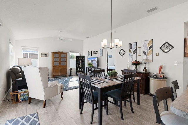 dining room featuring light wood-type flooring, ceiling fan with notable chandelier, and a healthy amount of sunlight