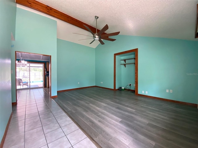 empty room with beamed ceiling, a textured ceiling, hardwood / wood-style flooring, and ceiling fan